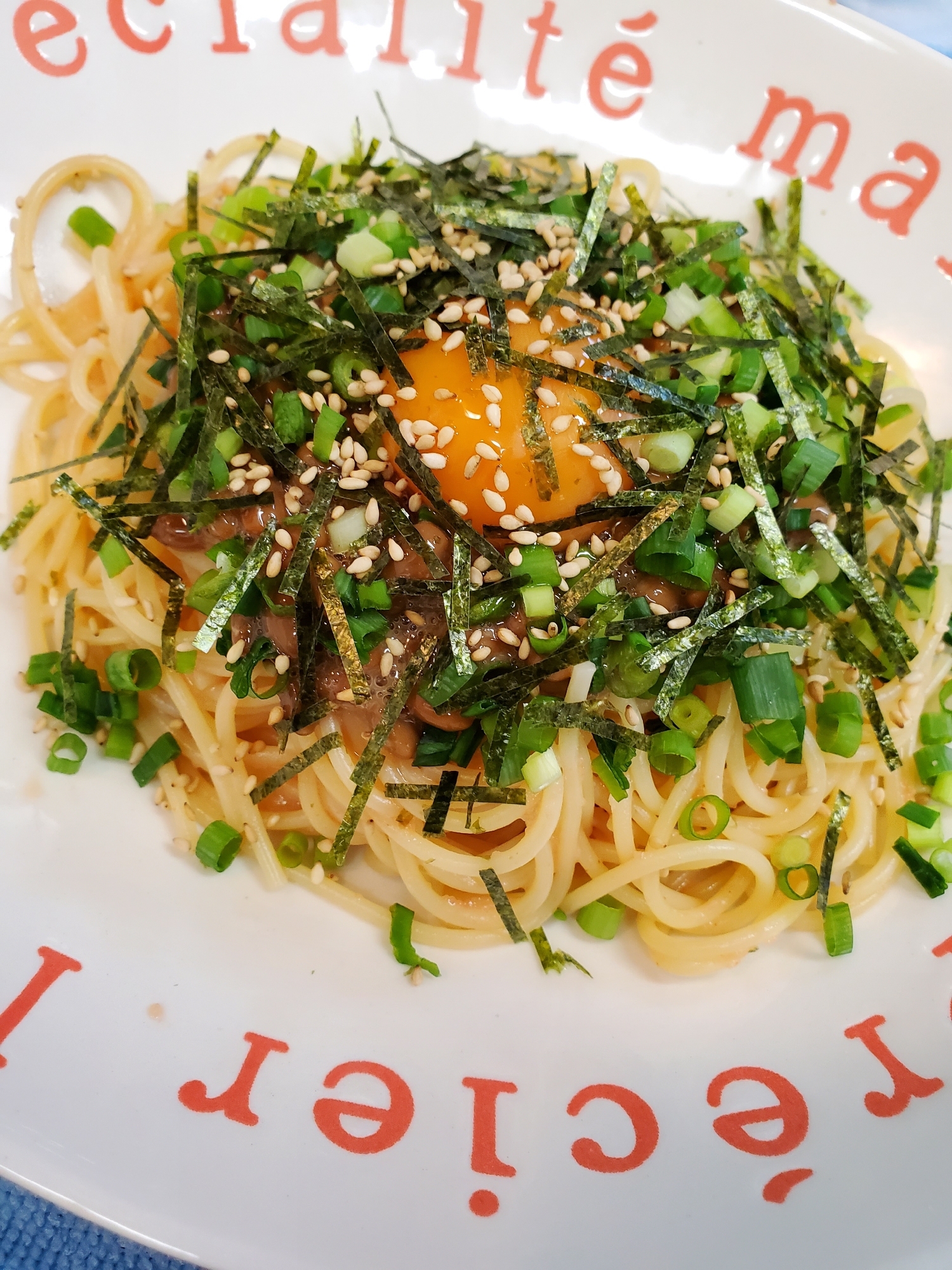 卵黄と小口ねぎをトッピングした納豆明太子ソースパスタ