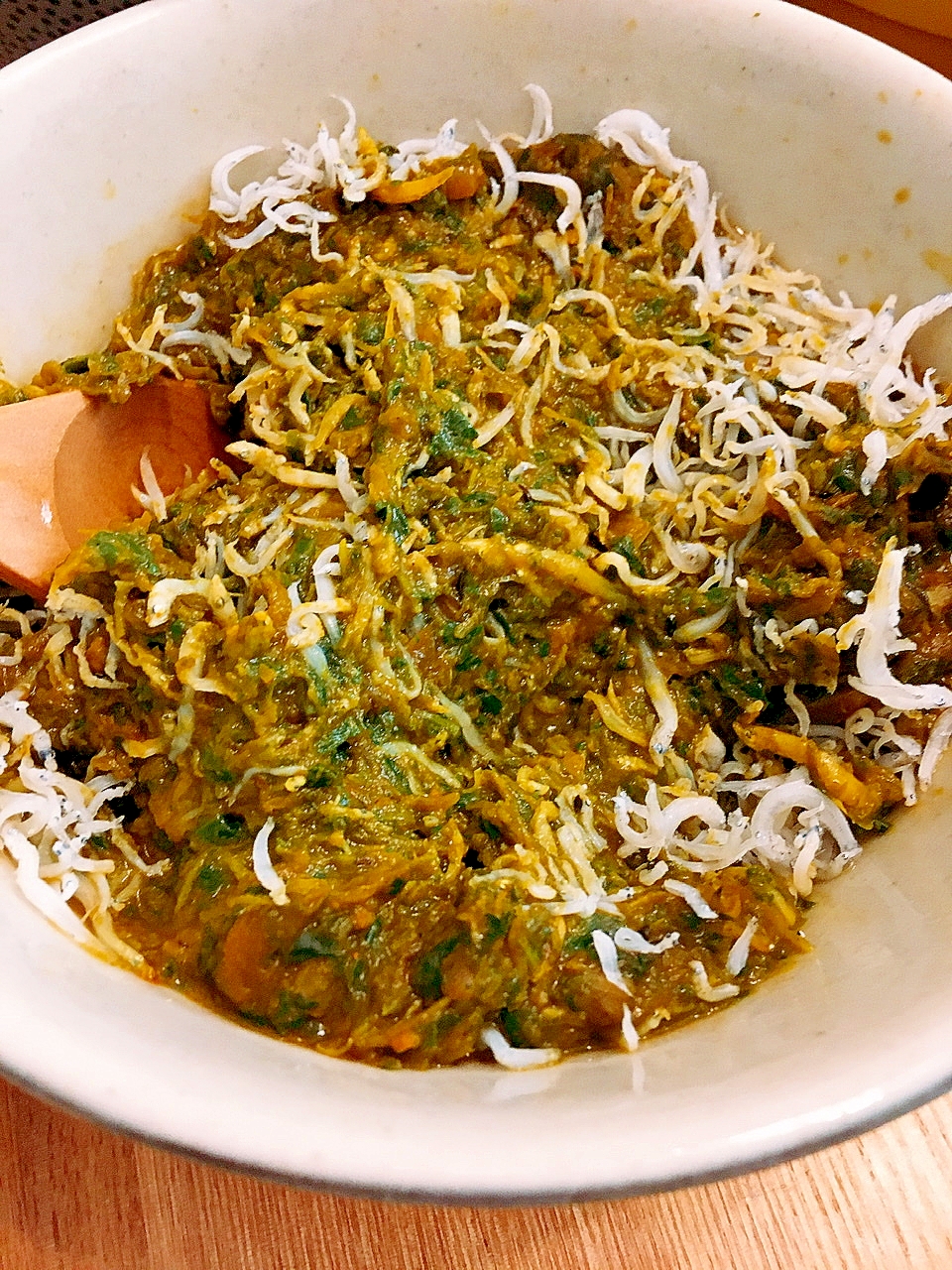 白い器に盛り付けられたかき菜としらす干しのサグカレー