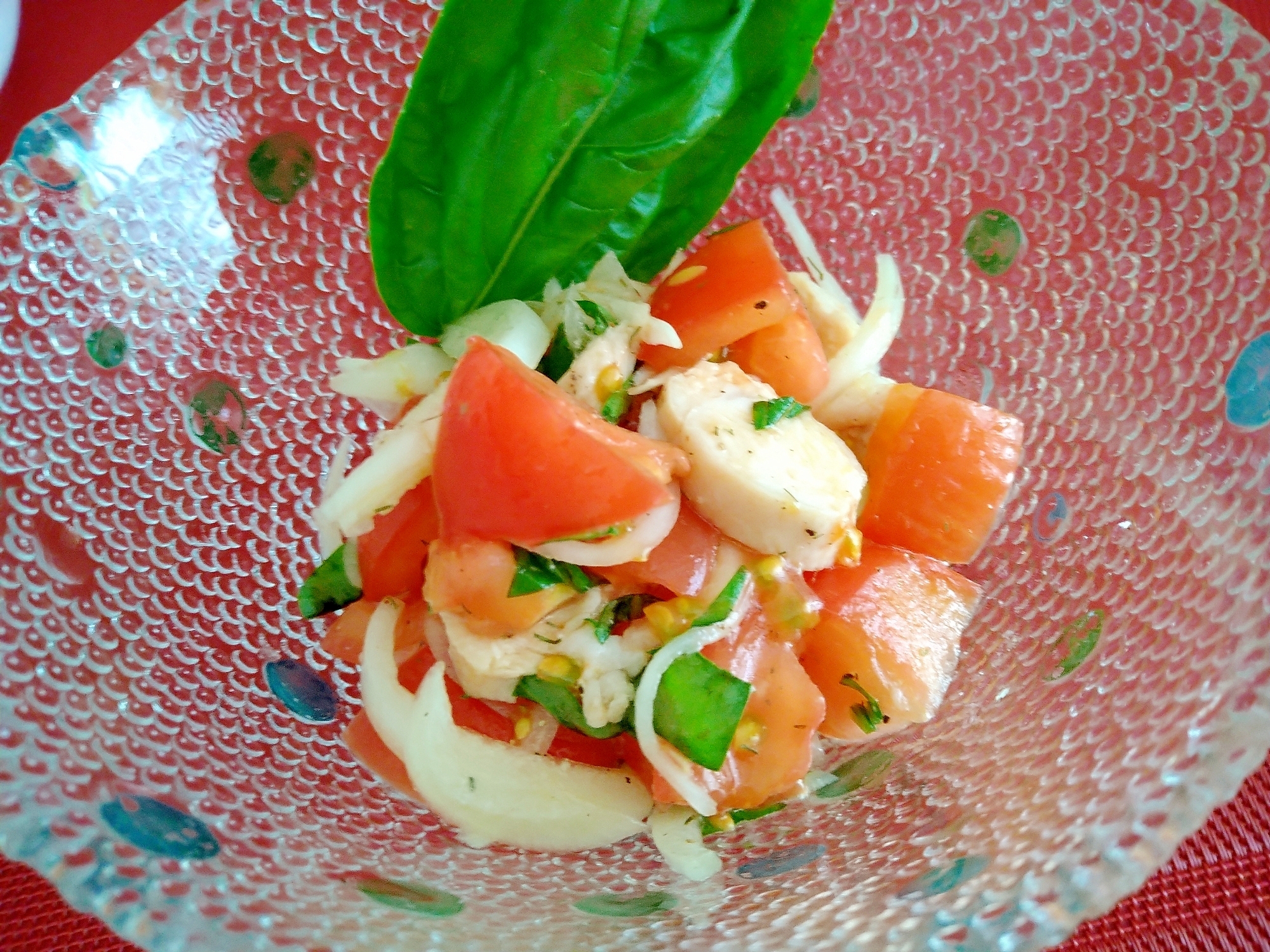 ガラスの器に盛り付けられた鶏ささみとトマトのバジルサラダ