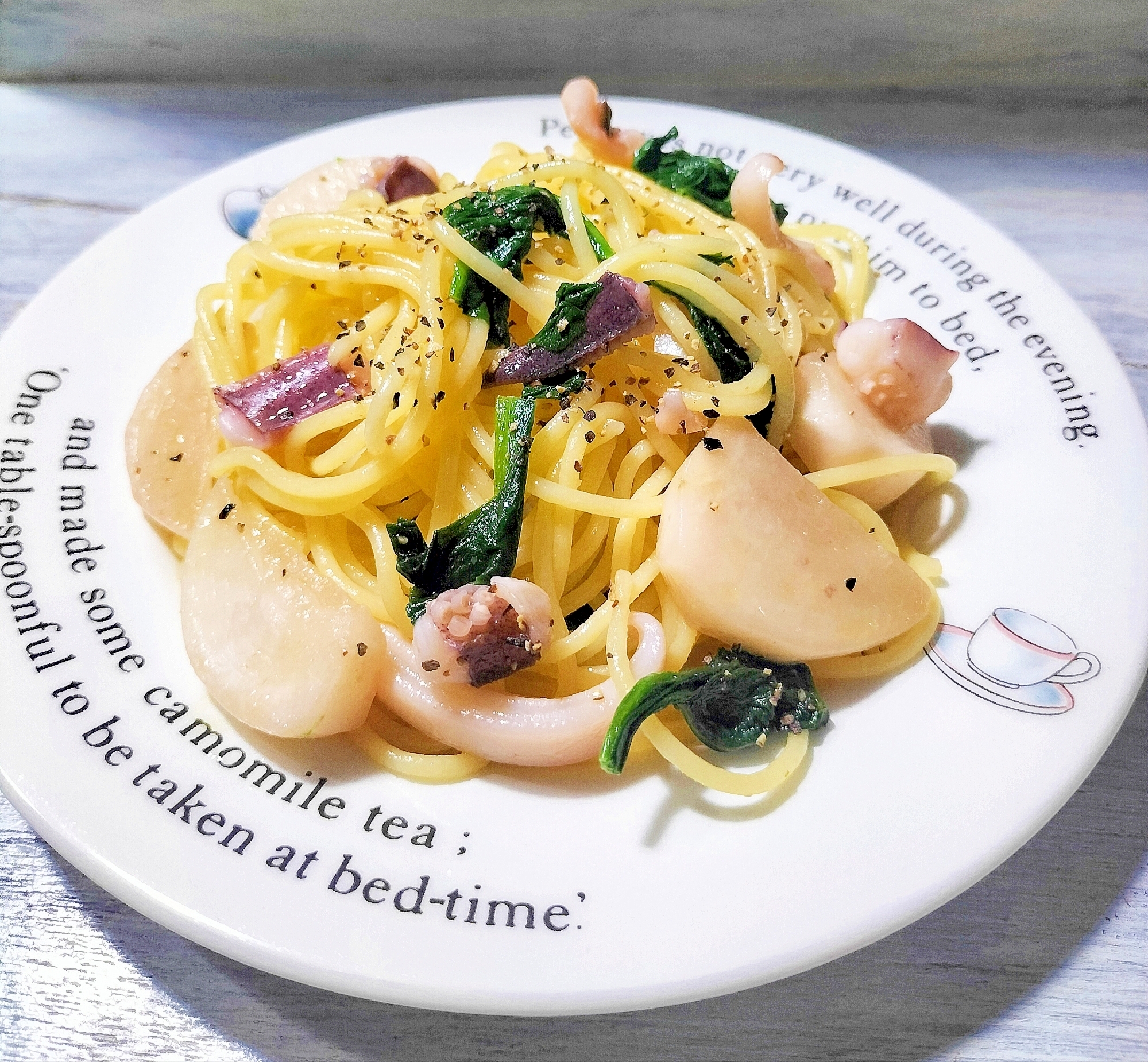 白い丸プレートに盛り付けたかぶとアオリイカのパスタ