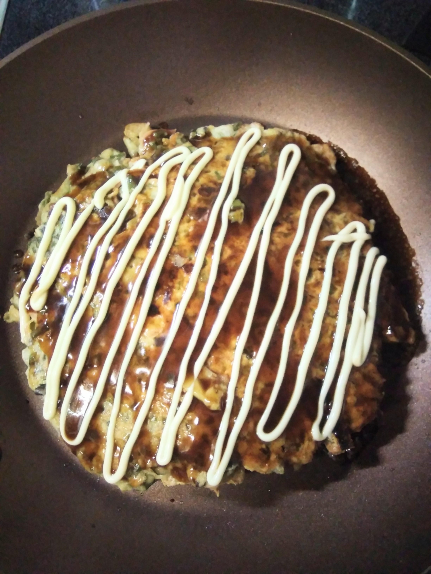 フライパンで焼いているわらびのお好み焼き