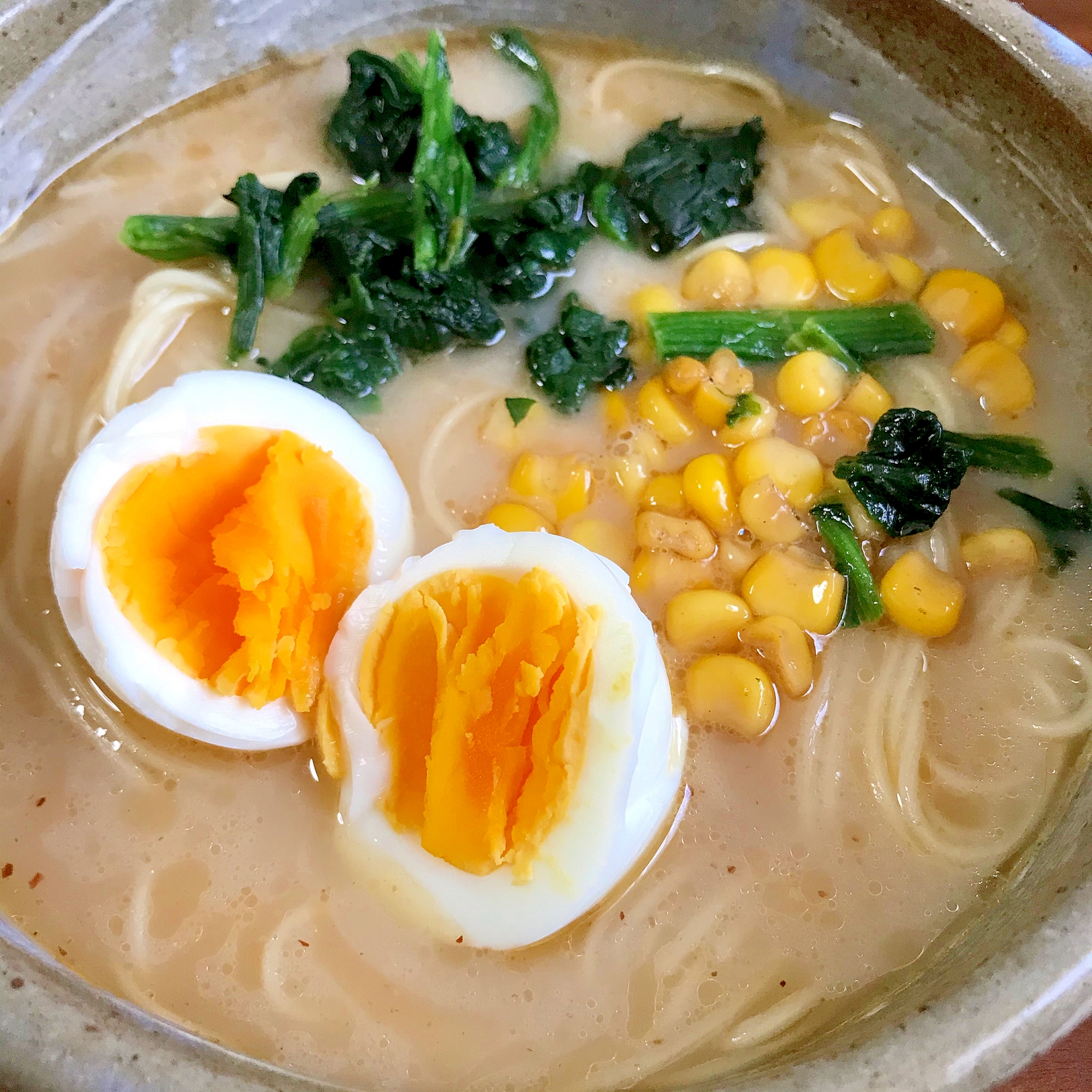 コーン、ほうれん草、ゆで卵を乗せたラーメン