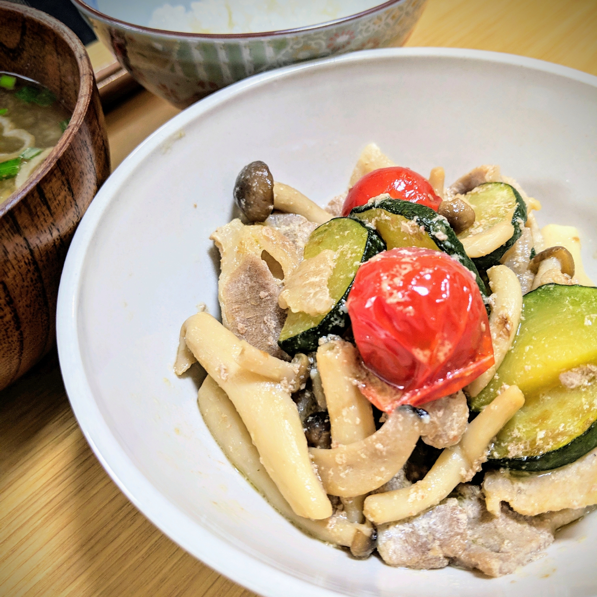 白色の丸皿に盛られた豚バラ肉とズッキーニとしめじのマヨポン炒め