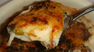 グラタン皿に入ったたことこんにゃくの和風グラタンを、スプーンですくっている様子