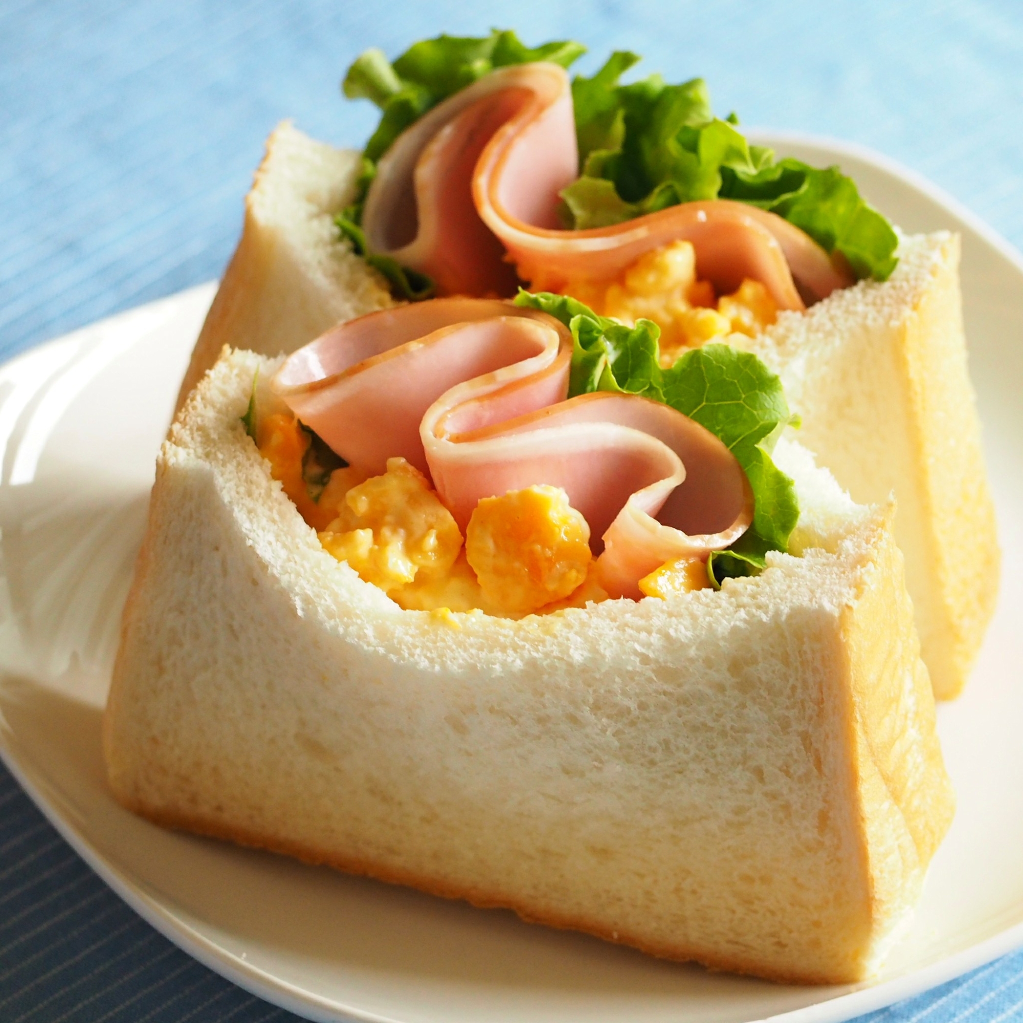 白色の皿に盛られた卵とハムのポケットサンド