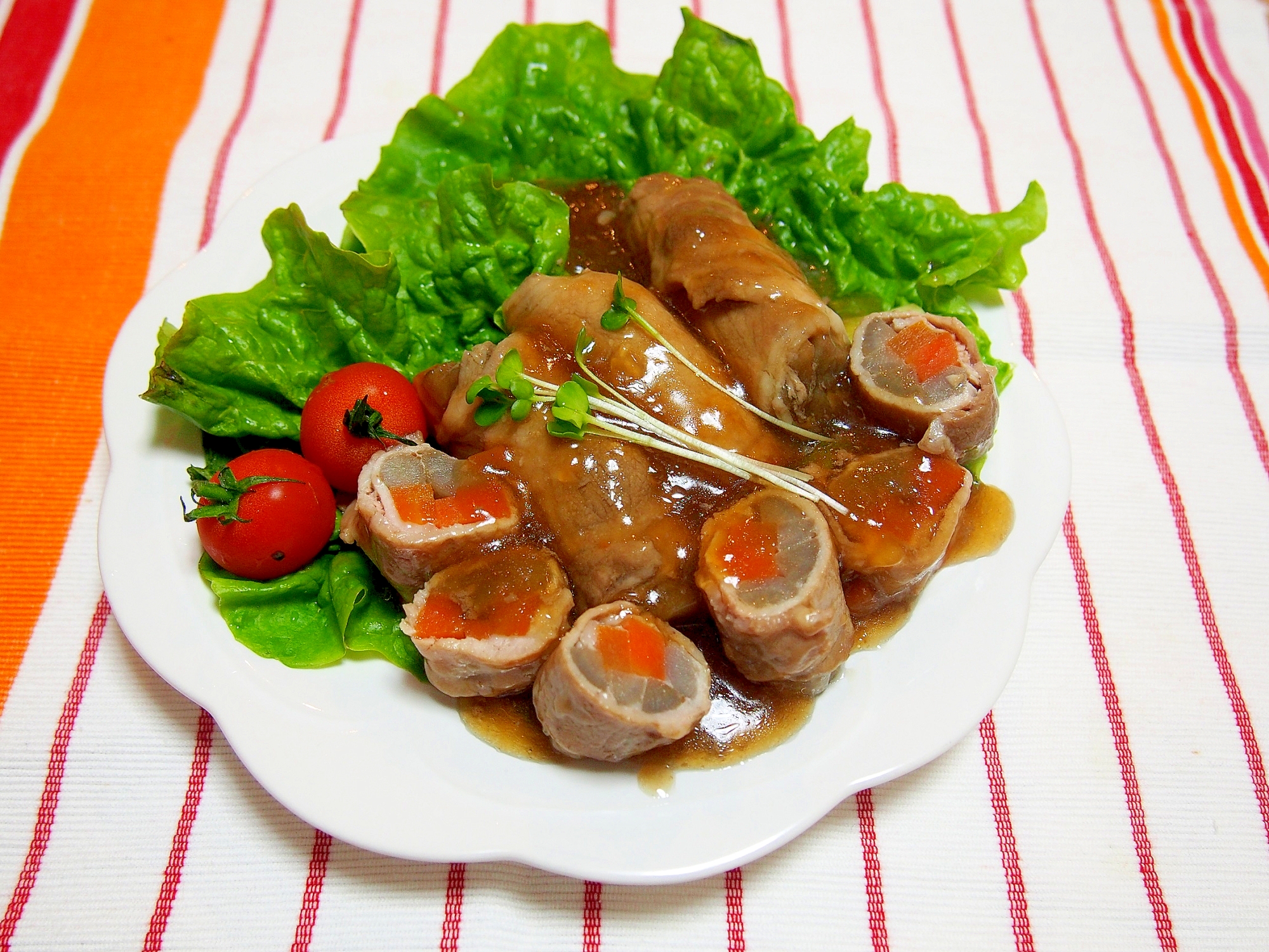 白い皿に盛り付けた肉巻きごぼうとにんじん