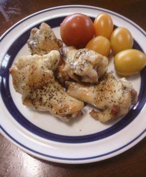 青い縁取りの皿に盛った手羽元のオリーブオイル焼きとミニトマト