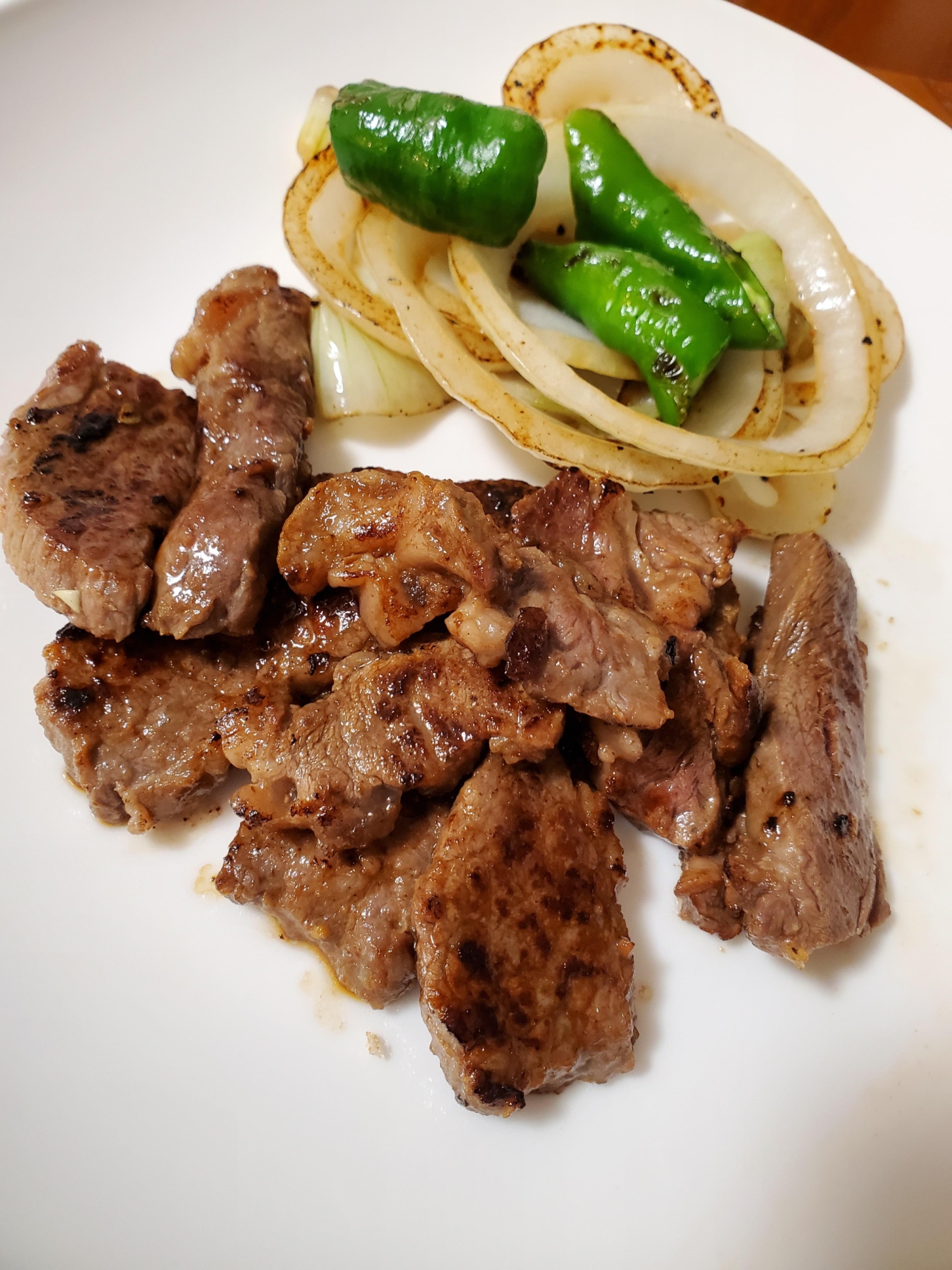牛肉のステーキと焼き野菜がのっている皿