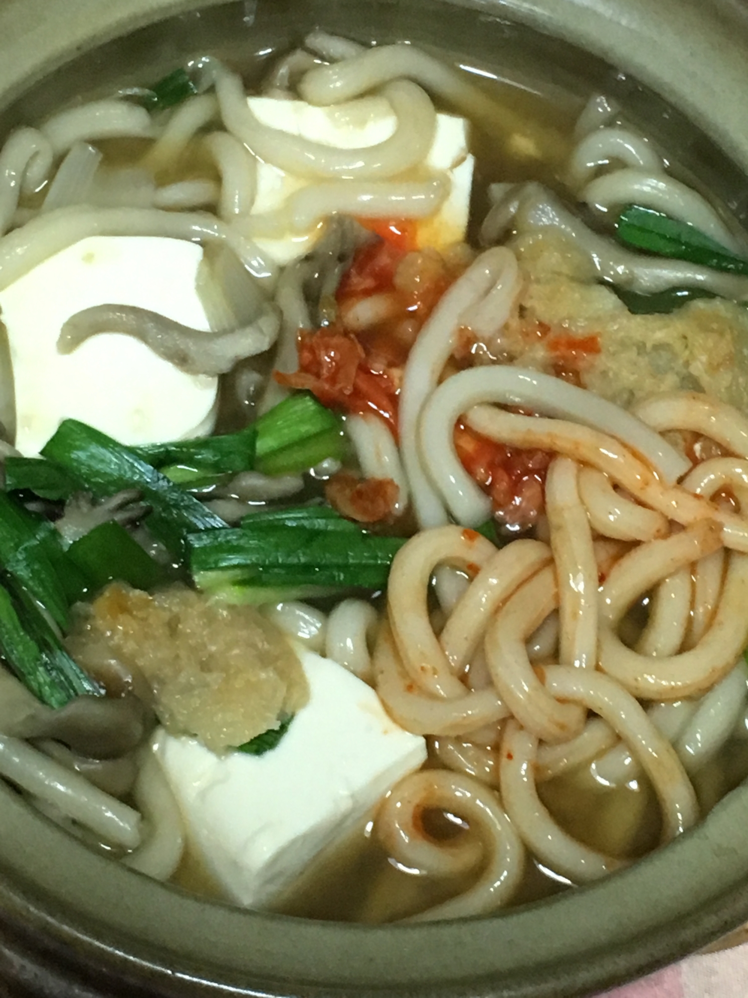 豆腐、にら、キムチ、舞茸、えび天ぷらの鍋焼きうどん