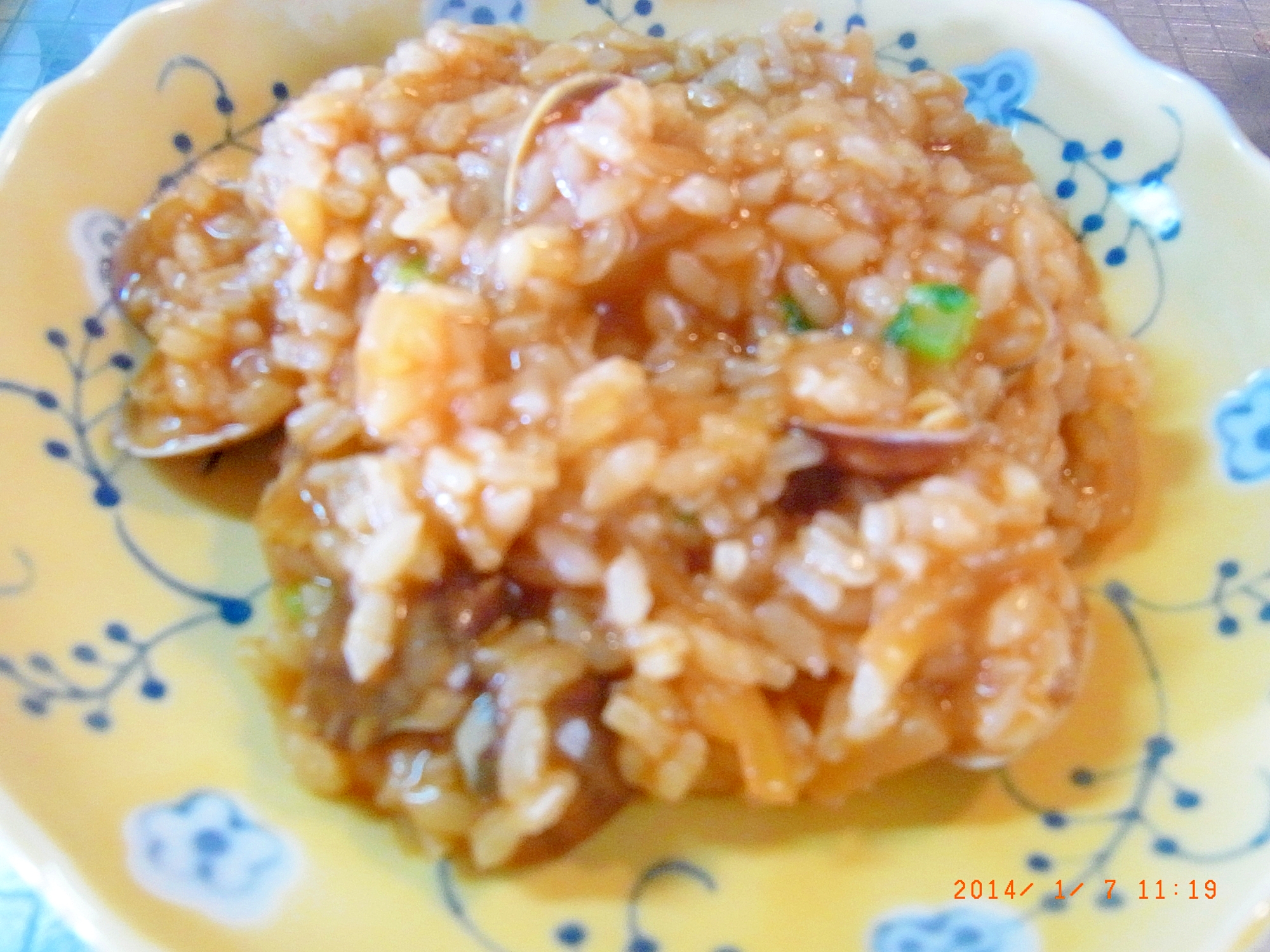 黄色いお皿に盛り付けられたあさりのトマトリゾット