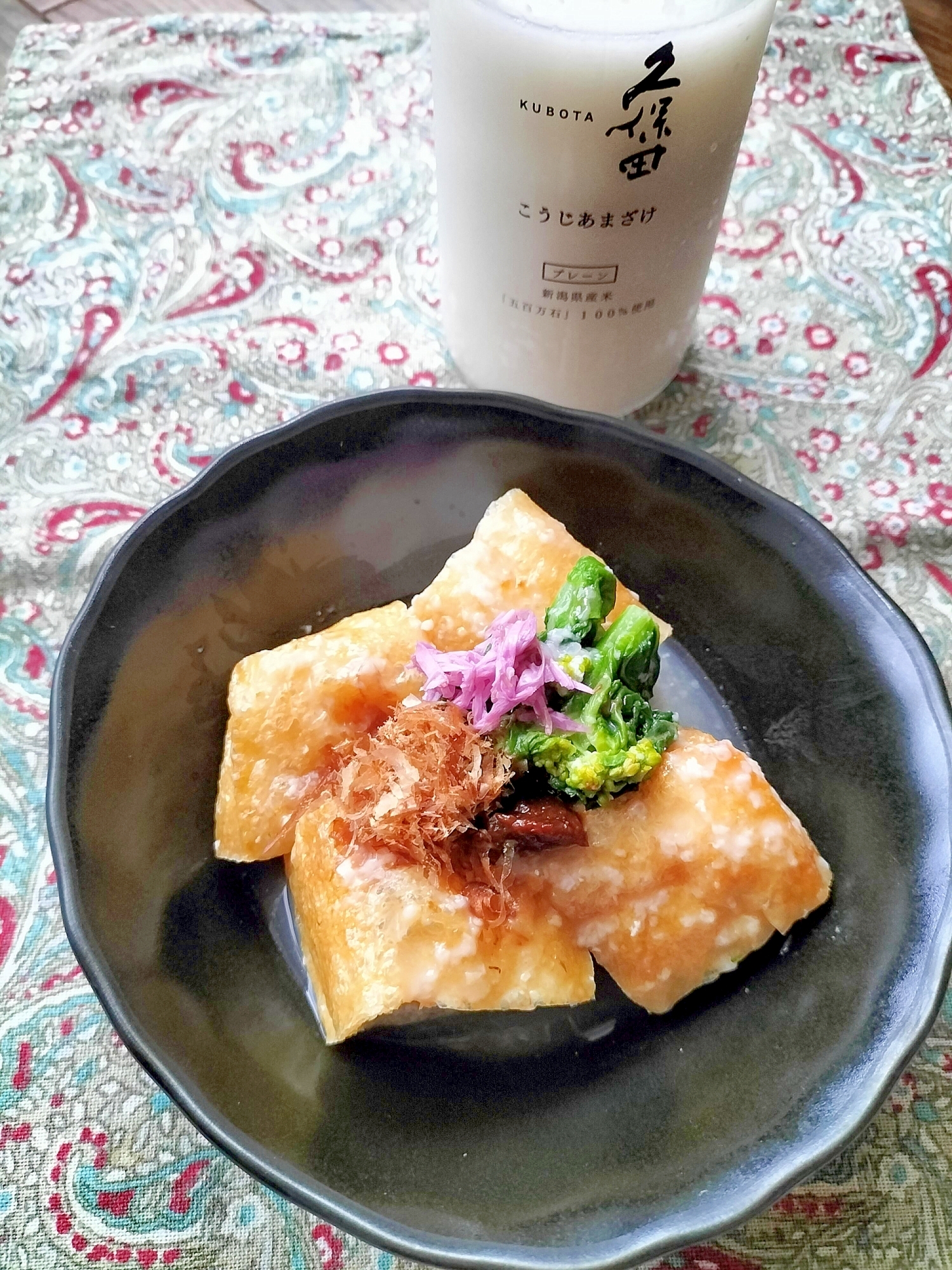 黒い皿に盛り付けた栃尾揚げの甘酒煮