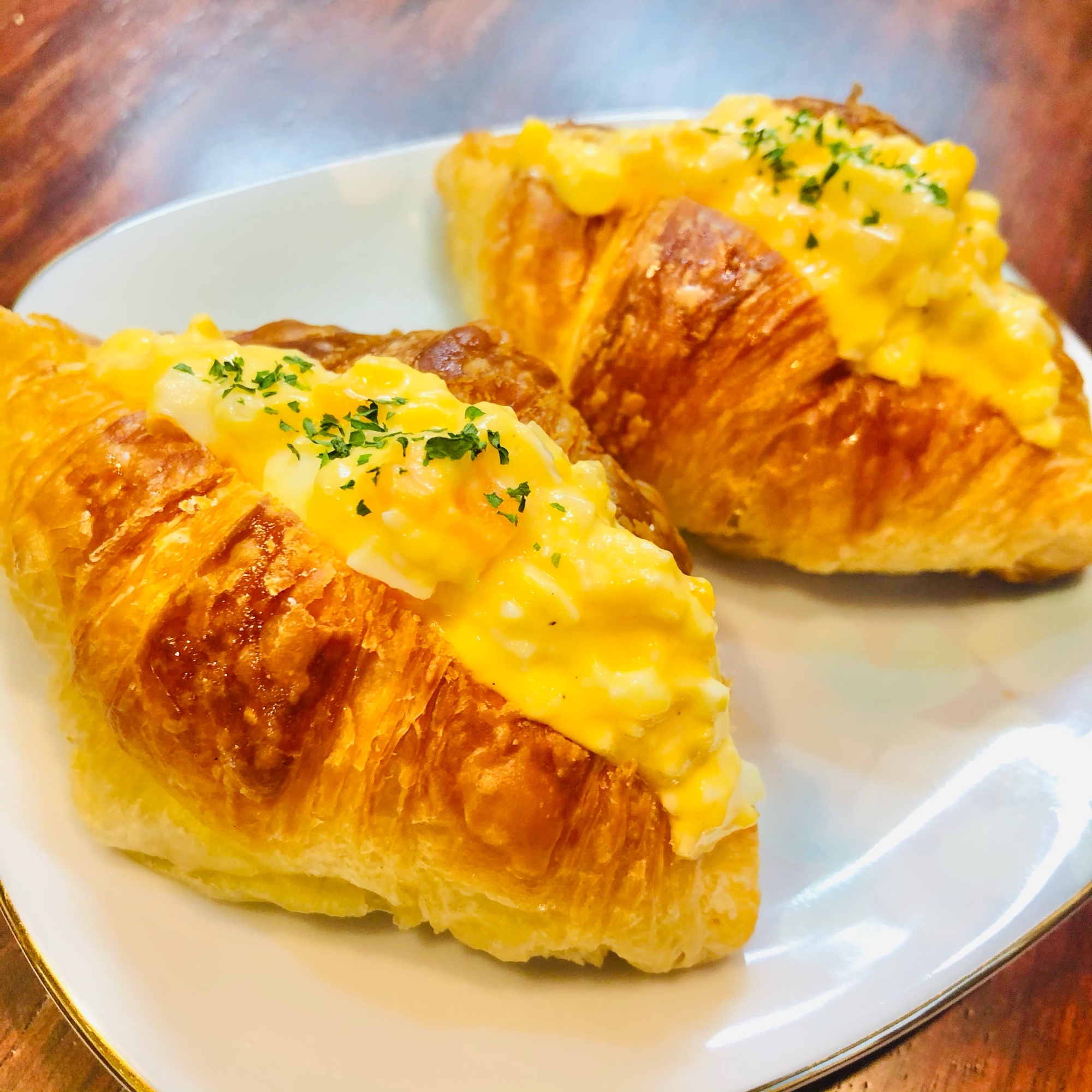 白い皿に盛られた、クロワッサンの卵サンド