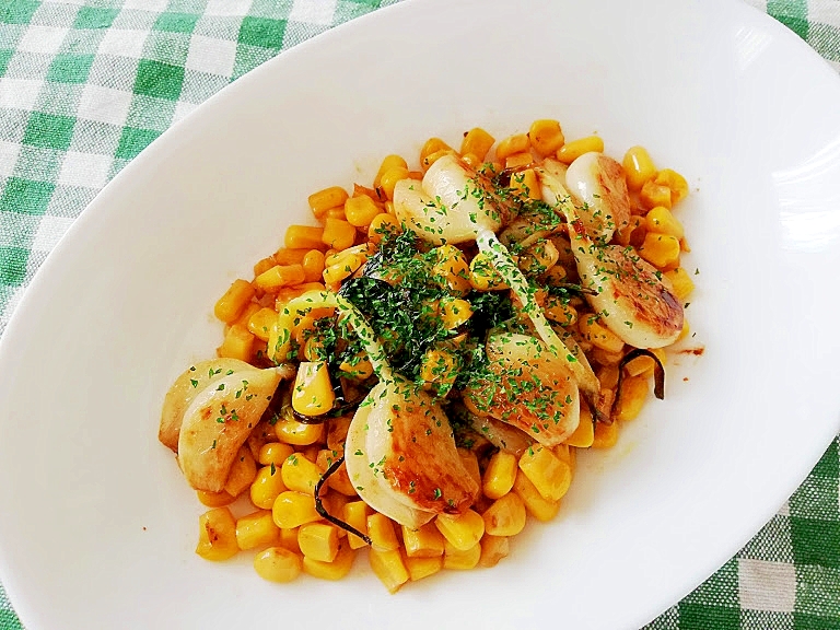 白いオーバル皿に盛り付けたまるごとにんにくとコーンのソテー