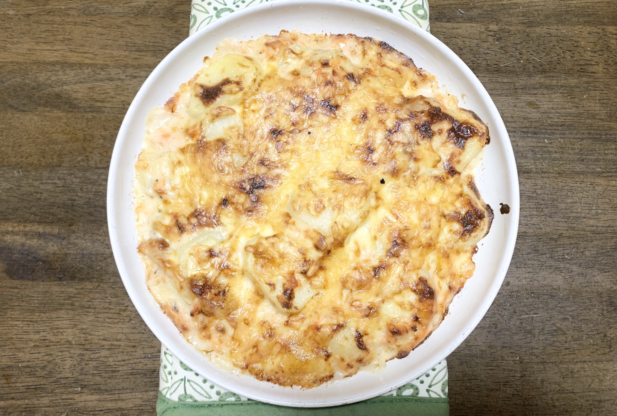 白い器に入った、じゃがいもと鮭のグラタン