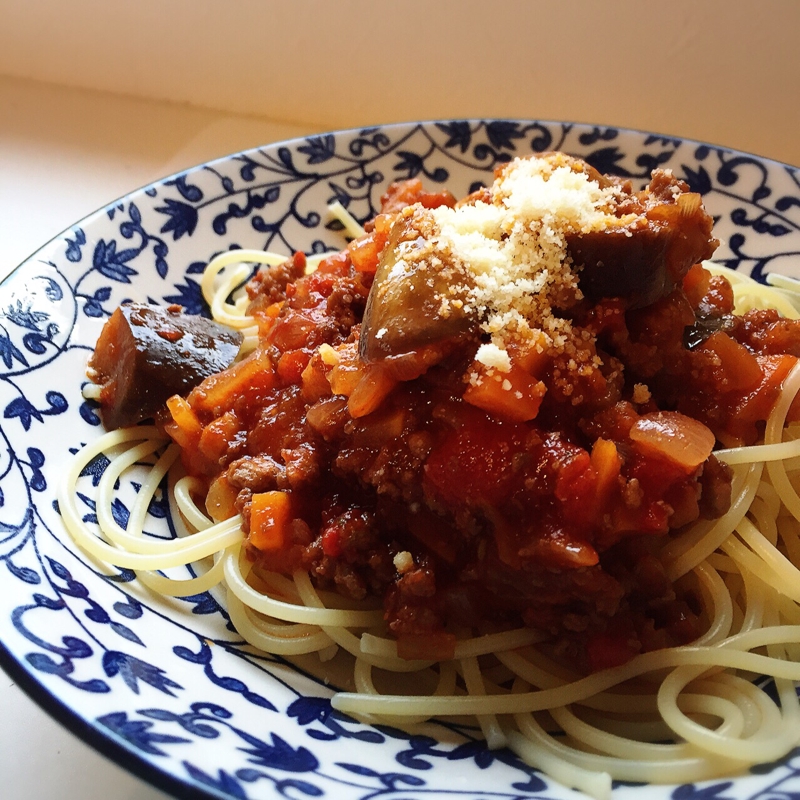 青と白のお皿に盛り付けられた野菜たっぷりのミートソースパスタ