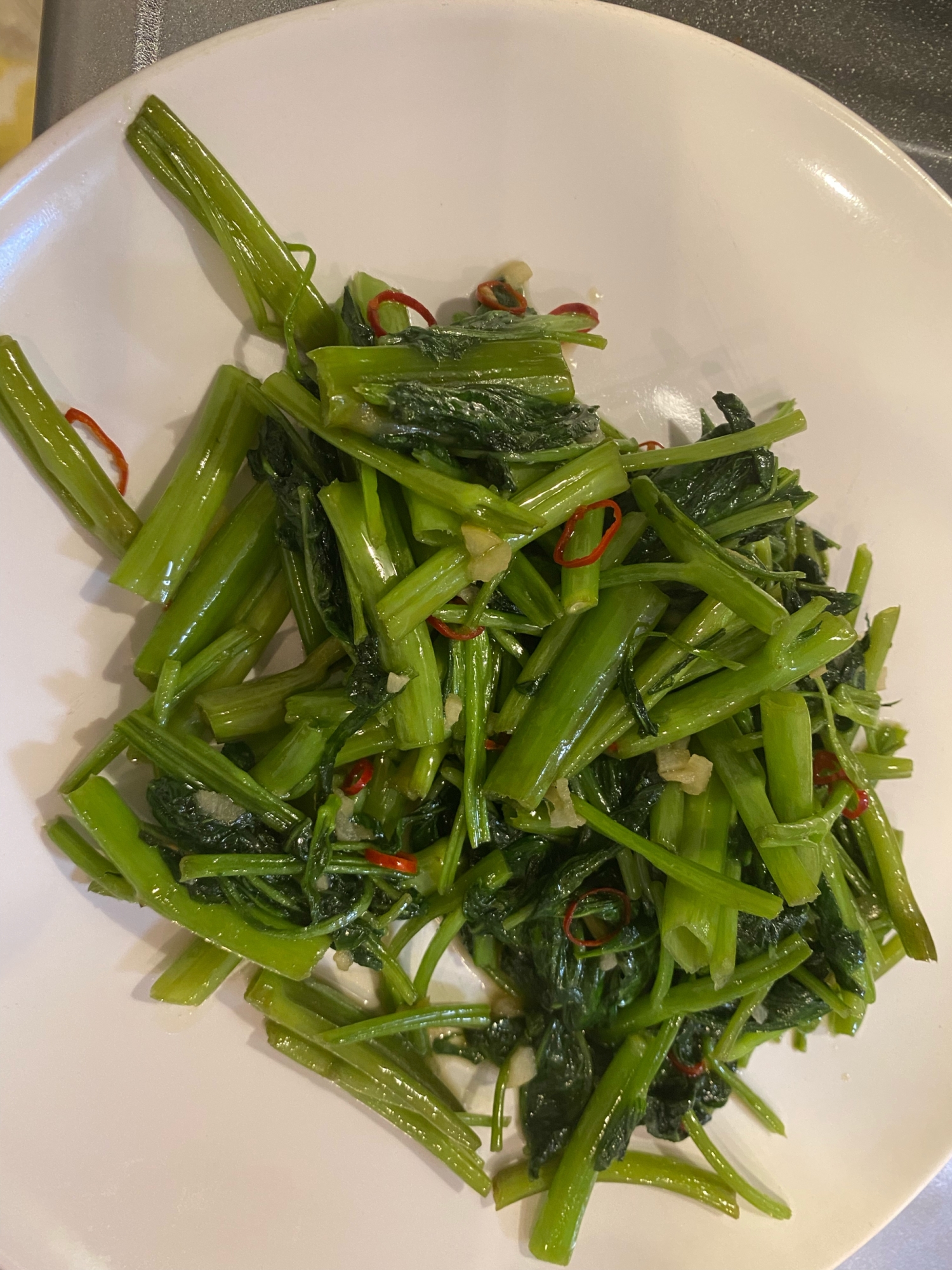 白い皿に盛り付けたエンサイのエスニック風炒め