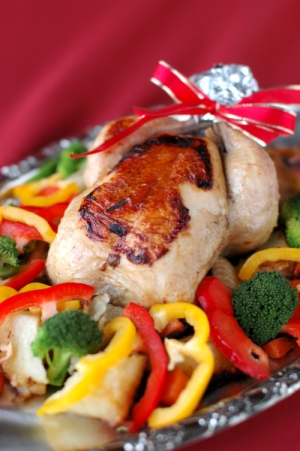 銀の皿に盛り付けた丸鶏のローストチキンと野菜