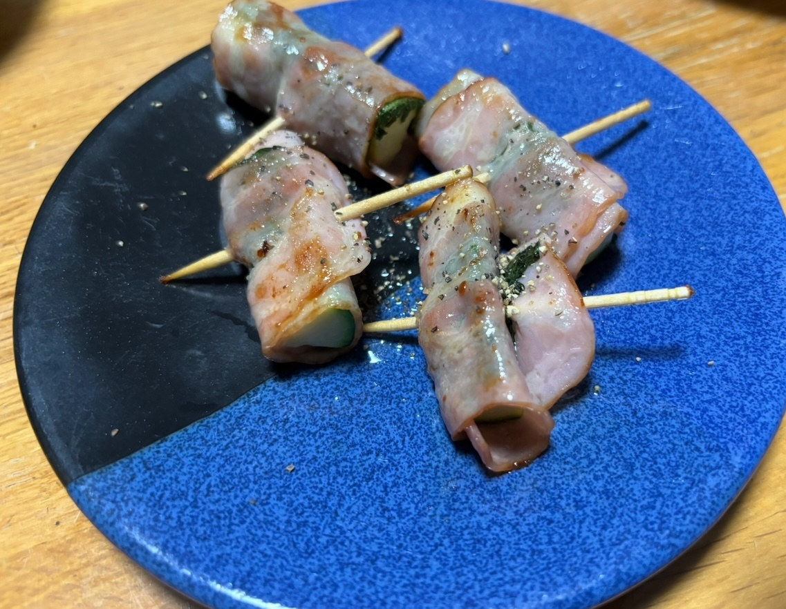 青色の丸皿に盛られた大葉とズッキーニのベーコン巻き