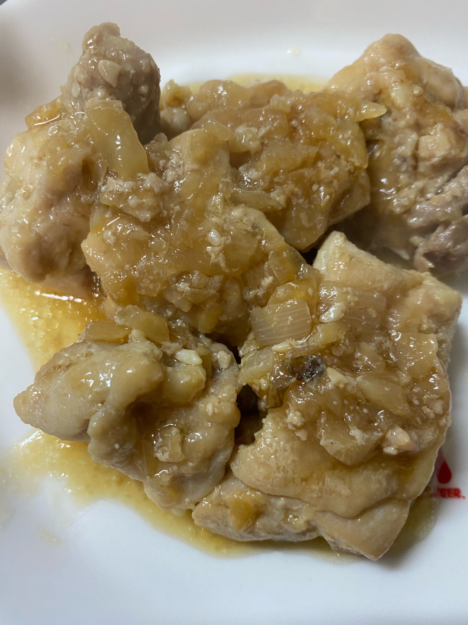 白い皿に盛られた、鶏肉の玉ねぎ醤油麹ソースがけ
