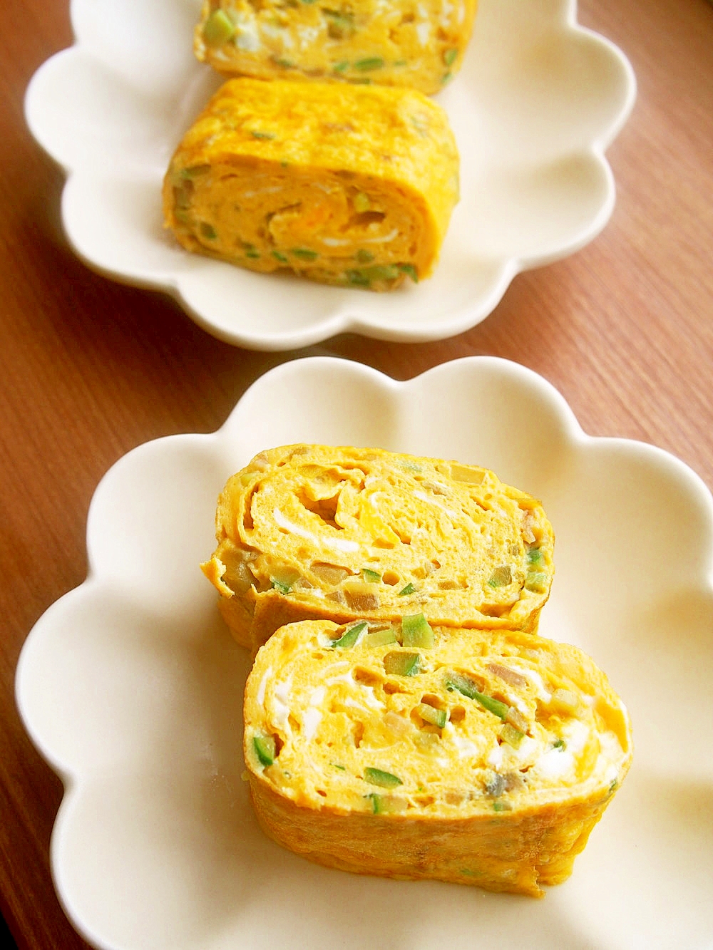 白い花形の皿に盛り付けた山形だしの卵焼き