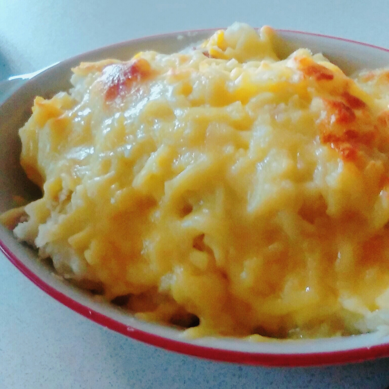 赤いグラタン皿に入ったサラミポテトグラタン