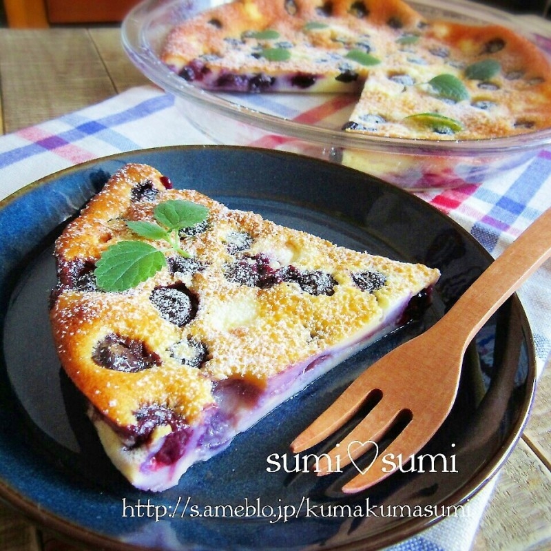 黒っぽい皿に、ブルーベリー入りの大きなケーキがのっている