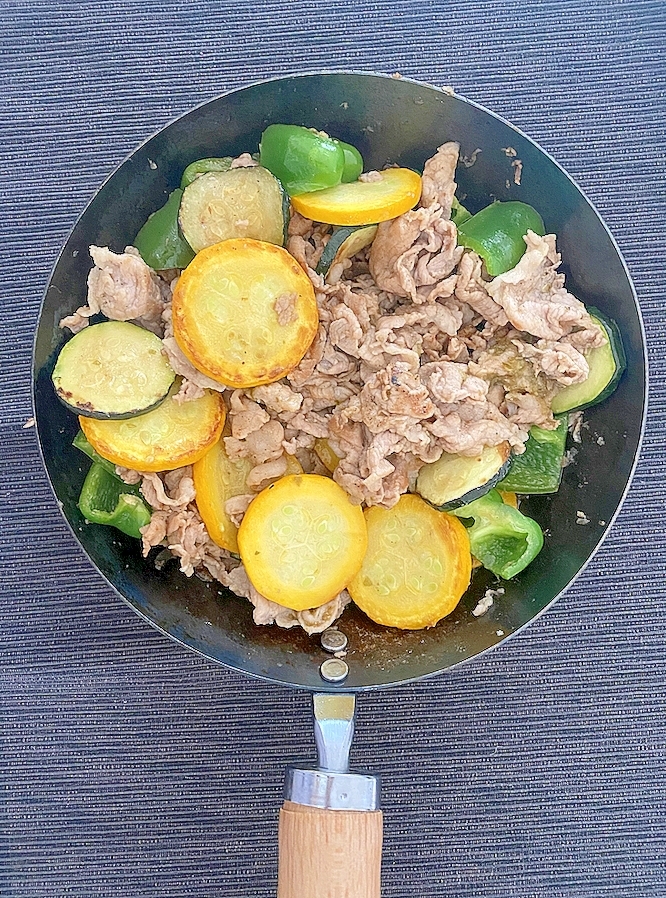 フライパンに入った豚バラ肉とズッキーニのポン酢炒め