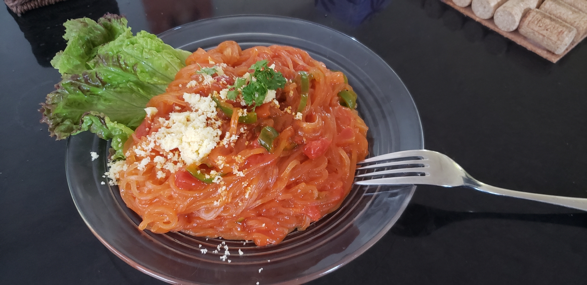 青いお皿に盛り付けられたマロニーのトマトソースパスタ