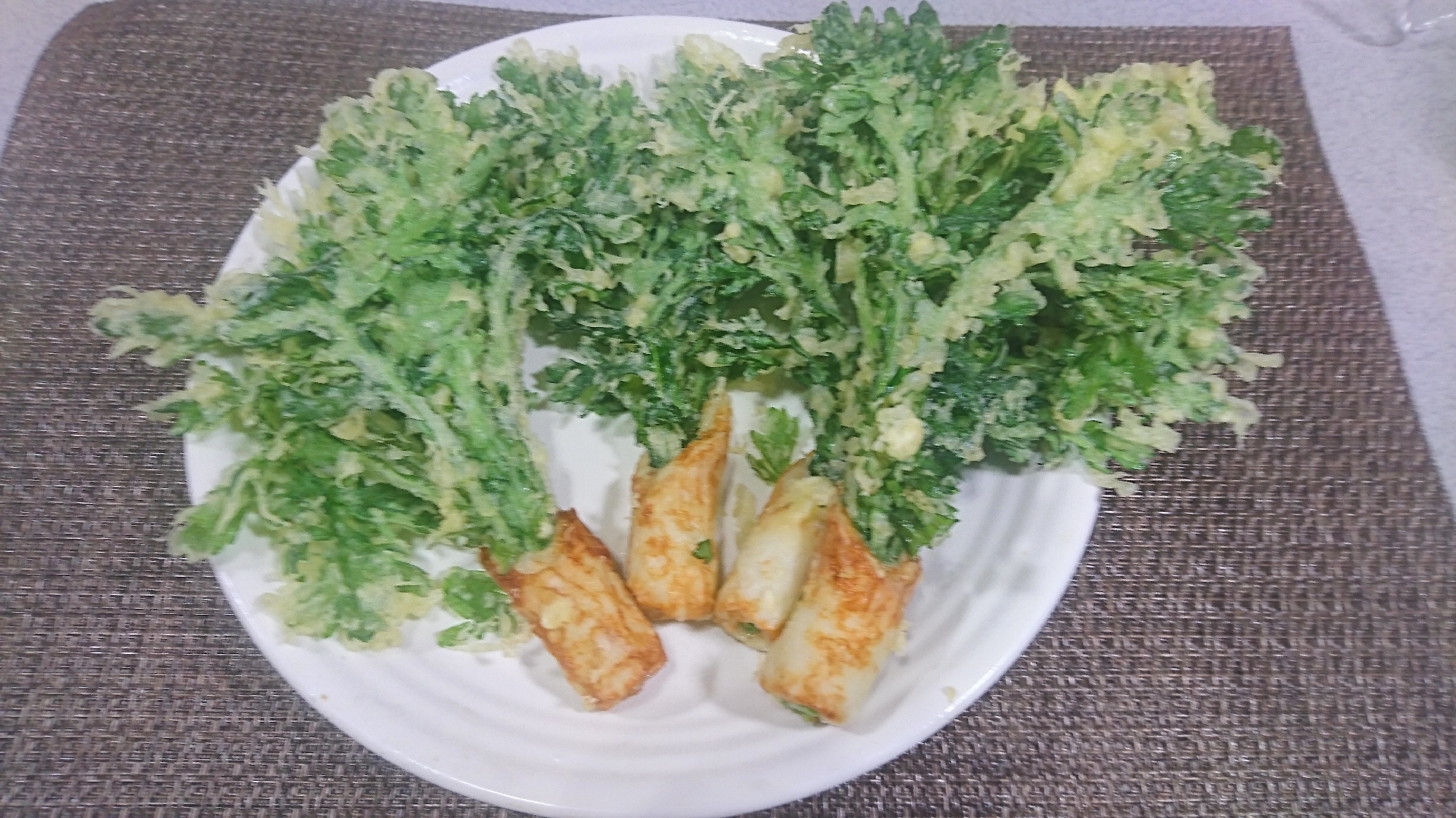 白い皿に盛られたちくわと春菊の天ぷら