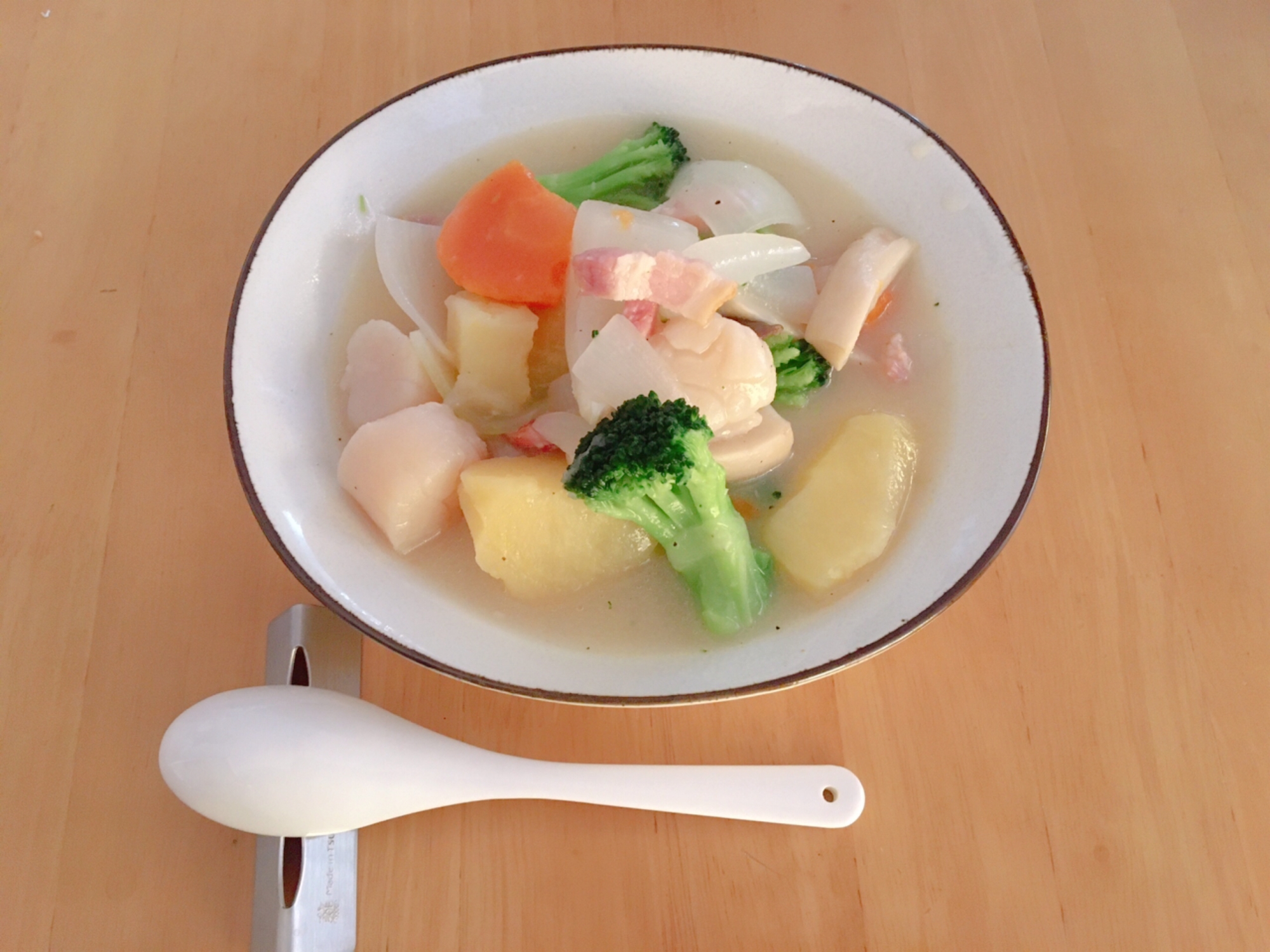 生ホタテとゴロゴロ野菜のクリームシチューが盛られた器とスプーン