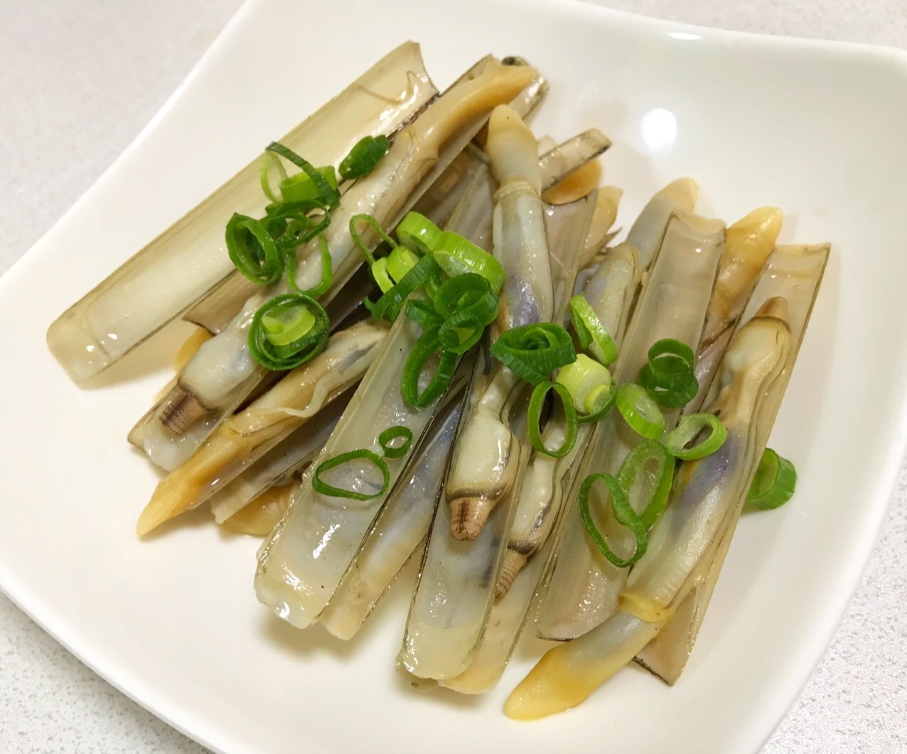 白い皿に盛り付けたマテ貝のバター炒め