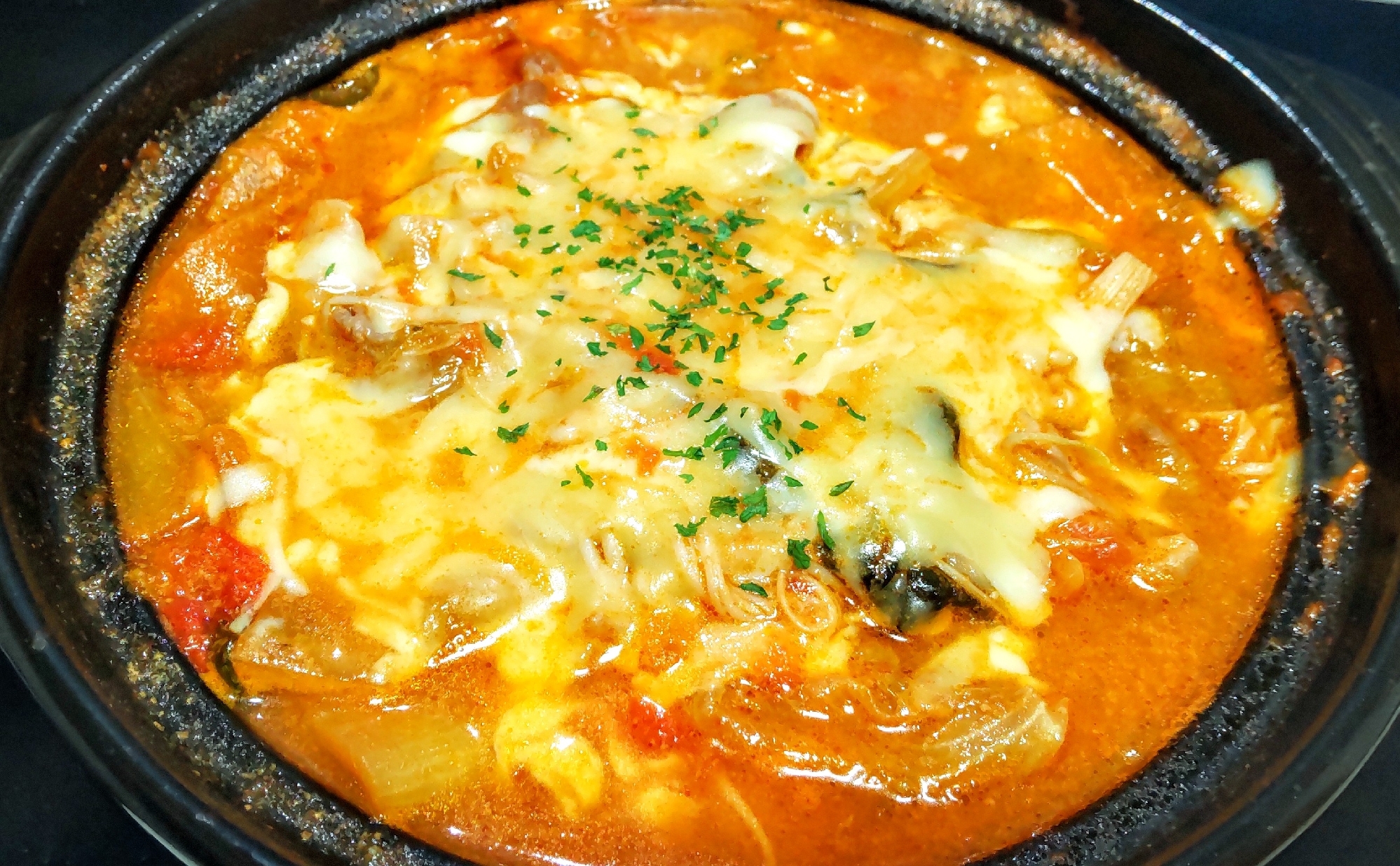 黒い鍋の中のトマトとチーズのレタス鍋