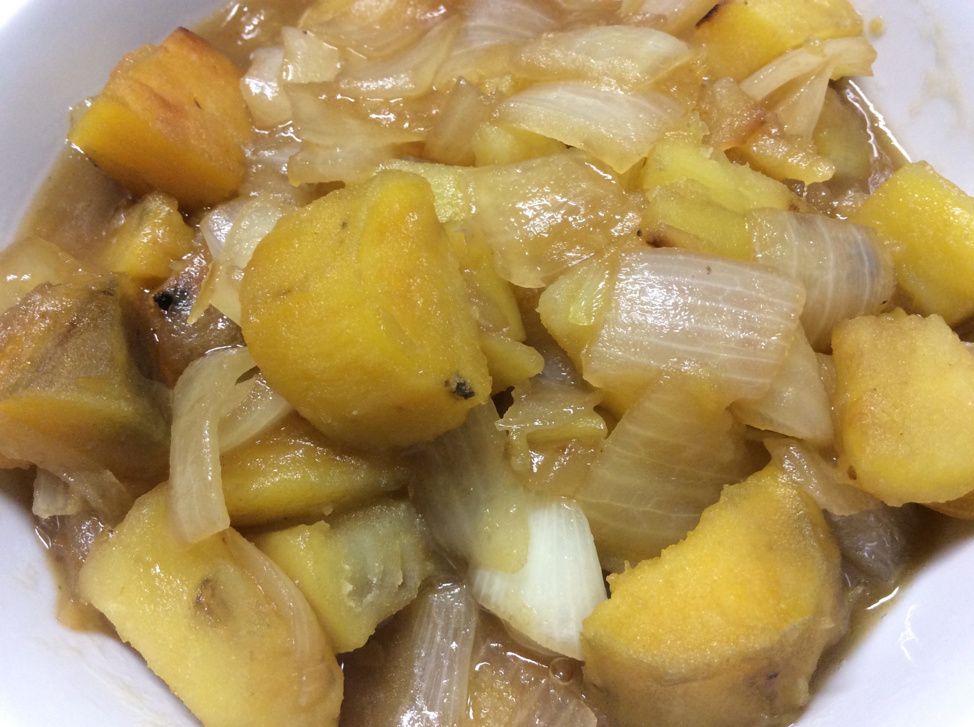 白色の皿に盛られたさつまいもと玉ねぎの甘辛煮込み