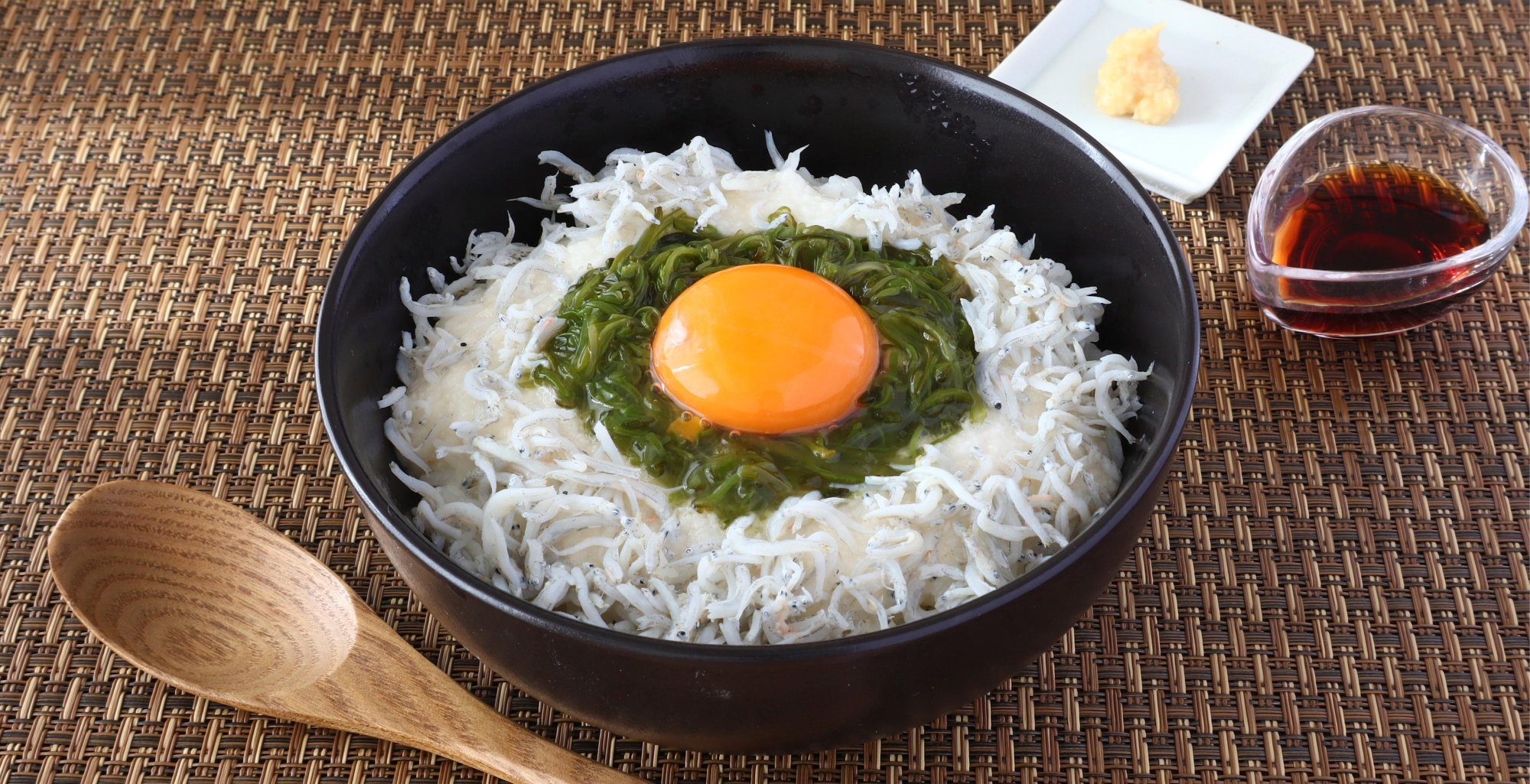 しらすとめかぶ、とろろ、卵黄がごはんにのっているところ