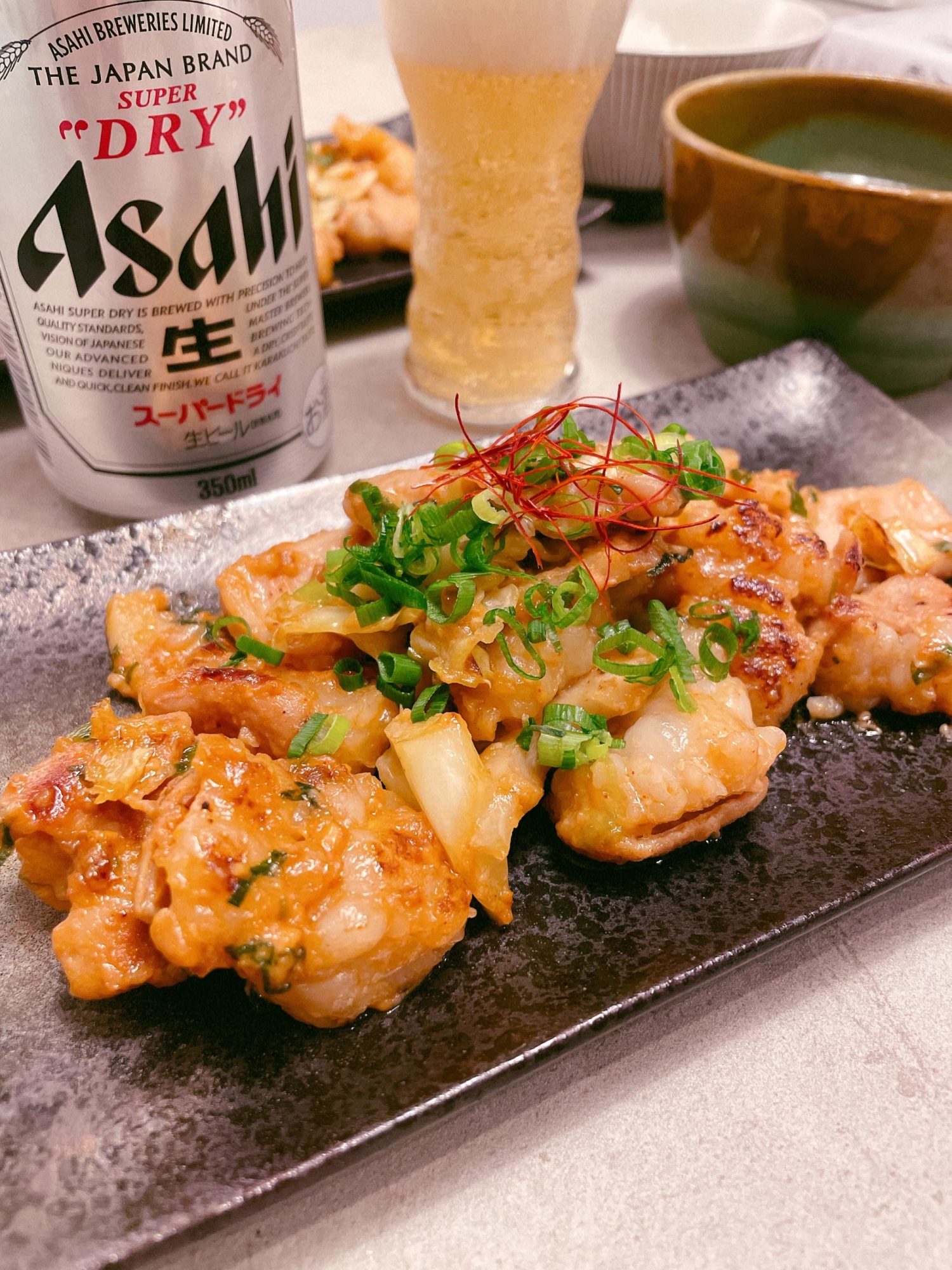 黒い皿に盛り付けた牛ホルモンのピリ辛にんにくみそ炒め