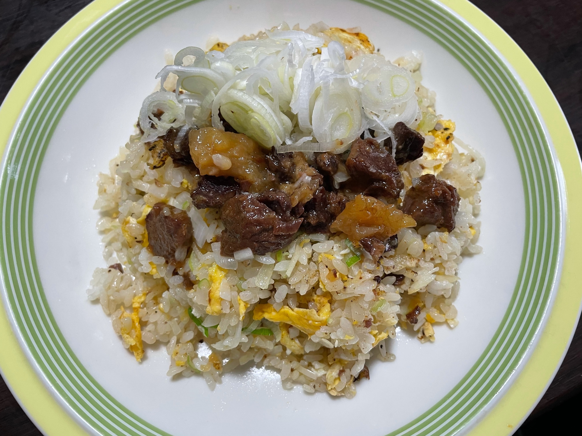 丸い皿に盛り付けられたくじらのアヒージョチャーハン