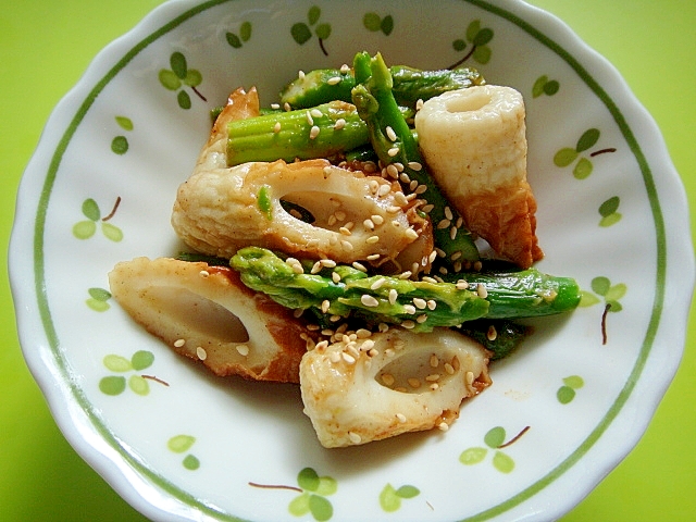 緑色の葉の絵が描かれた丸皿に盛られた冷凍アスパラとちくわのめんつゆマヨ炒め