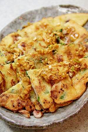 灰色の楕円の皿に盛られた海鮮チヂミ