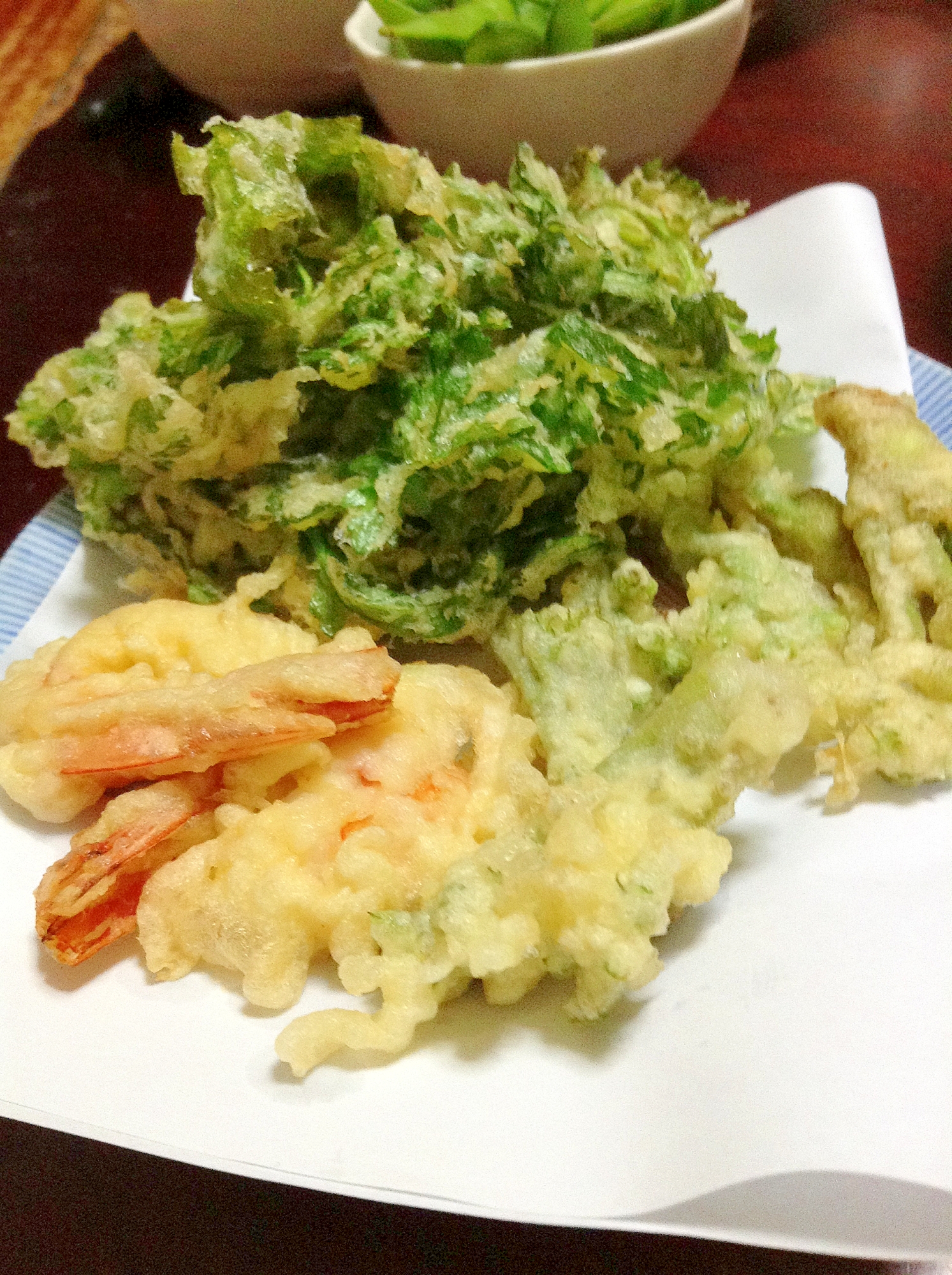 白い皿に盛られた、春菊のガーリック天ぷらとえびの天ぷら